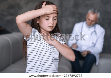 Selective focus on girl patient feeling unwell, has throat sore and grippe symptoms during doctor visiting at home. Child suffering from headache, weakness and high temperature. Health care concept