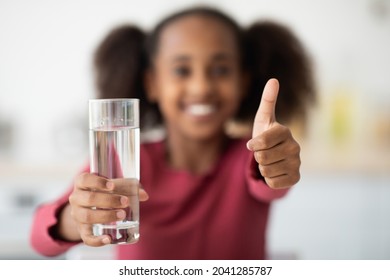 Selective Focus On Glass Of Water And Thumb Up, Unrecognizable Black Girl Drinking Water, African American Teen Kid Recommending Fresh Spring Water, Closeup. Kids Hydration Cocnept