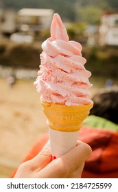 Selective Focus On Hand Holding Pink Soft Sakura Ice Cream Cone Bokeh Sakura Scenery Background Festive Happy Romantic Warm Feeling