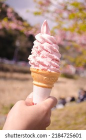 Selective Focus On Hand Holding Pink Soft Sakura Ice Cream Cone Bokeh Sakura Scenery Background Festive Happy Romantic Feeling