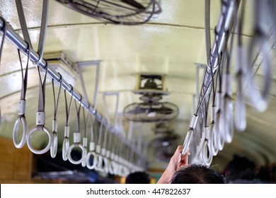 selective focus on hand holding old handrail in public train transportation, undefined man standing back - Shutterstock ID 447822637