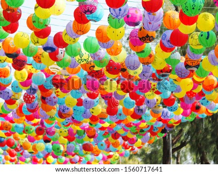 selective focus on hand painted paper ball lanterns hanging over a street of KHON KAEN province, THAILAND on daytime showing unique rural decorative style LOIKRATHONG: THAI floating candles festival