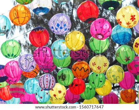 selective focus on hand painted paper ball lanterns hanging over a street of KHON KAEN province, THAILAND on daytime showing unique rural decorative style LOIKRATHONG: THAI floating candles festival