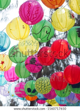 selective focus on hand painted paper ball lanterns hanging over a street of KHON KAEN province, THAILAND on daytime showing unique rural decorative style LOIKRATHONG: THAI floating candles festival