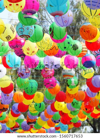 selective focus on hand painted paper ball lanterns hanging over a street of KHON KAEN province, THAILAND on daytime showing unique rural decorative style LOIKRATHONG: THAI floating candles festival