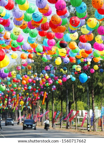 selective focus on hand painted paper ball lanterns hanging over a street of KHON KAEN province, THAILAND on daytime showing unique rural decorative style LOIKRATHONG: THAI floating candles festival