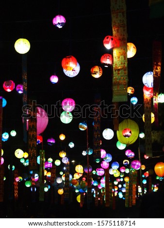 selective focus on hand painted paper ball lanterns along main entrance street of KHON KAEN university in KHONKAEN province, THAILAND on nighttime showing unique decorative style LOIKRATHONG festival