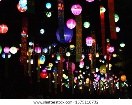 selective focus on hand painted paper ball lanterns along main entrance street of KHON KAEN university in KHONKAEN province, THAILAND on nighttime showing unique decorative style LOIKRATHONG festival