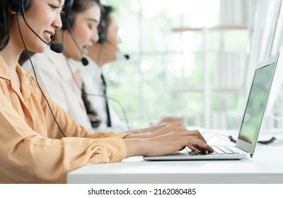 Selective Focus On Hand Of Young Operator Woman Typing And Working With Headset Smiling And Doing Customer Support At Work. Group Of Asian Employee Work In Telemarketing Customer Service Teams