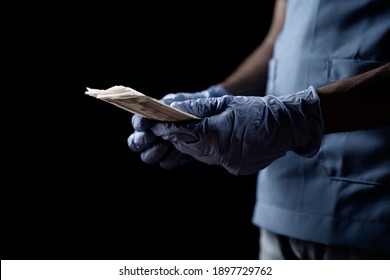 Selective focus on hands with added grain matte filter, Doctor or nurse with hand gloves counting money - concept of corruption, crime, income, savings and health insurance