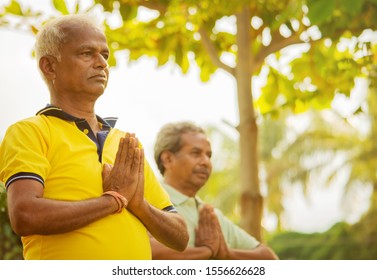 Selective focus on hands elderly men practising simple yoga - fitness, sport, yoga and healthy lifestyle concept - Two senior men with namaste posture at park outdoor. - Powered by Shutterstock