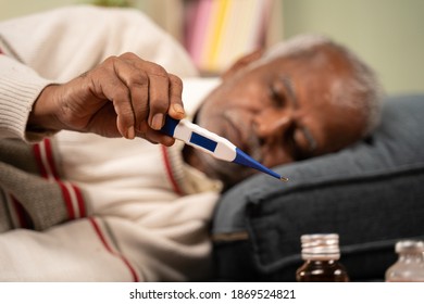 Selective Focus On Hands, Sick Bed Ridden Old Man Seeing Temperature On Thermometer While Sleeping At Home