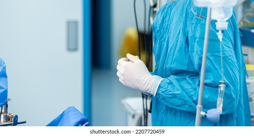 Selective focus on the hands of the surgeon in sterile gloves in the operating room. - Shutterstock ID 2207720459