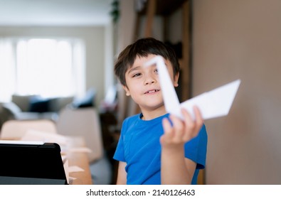 Selective focus on Happy school boy eyes looking at origami Swan paper. Kid learning paper art origami lesson, Child having fun doing Art and Craft at home, Home schooling concept