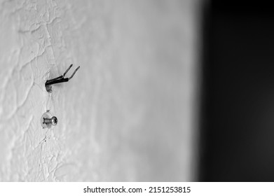 Selective Focus On Hole In A Residential Wall With Two Wires Sticking Out For Surround Sound Speakers.