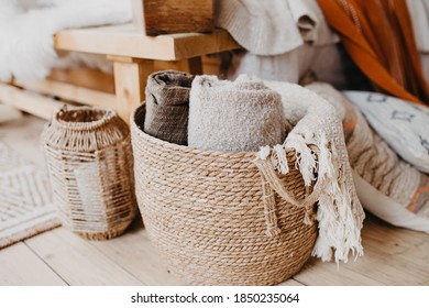 Selective Focus On Home Decor. Comfortable Bedroom In Bohemian Interior Style With Textile Sheet On Bed, Wooden Bench Seat, Wicker Basket