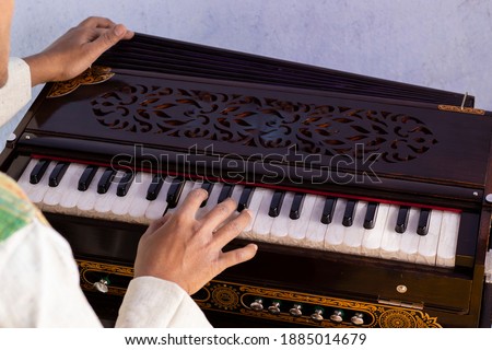 selective focus on human hand playing harmonium - indian classical instruments