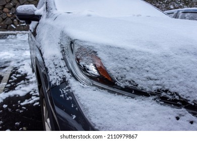 Selective Focus On An Icy, Snow Covered Car Headlights During A Snowstorm In The Pacific Northwest Woodlands