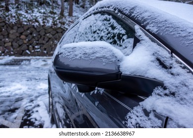 Selective Focus On An Icy, Snow Covered Car Rear View Mirror During A Snowstorm In The Pacific Northwest Woodlands