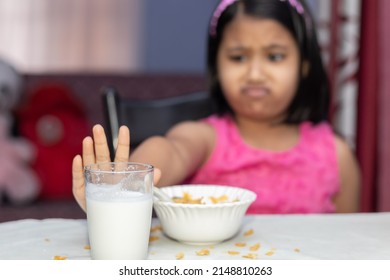 Selective Focus On An Indian Girl Child With Incomplete Meal Of Cornflakes And Milk Showing Dislike