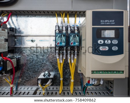 The selective focus on an inverter to control the rpm of motor which is the heart of machine in an industry. Besides are fuse and magnetic wiring along the busbar behind.