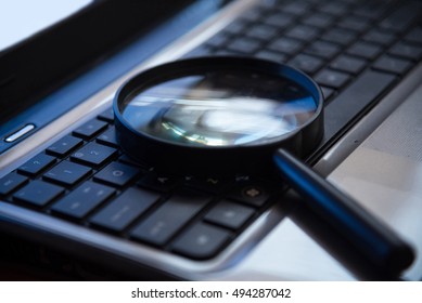 Selective focus on keyboard with magnifier searching concept in dark low key night tone