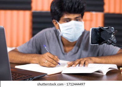 Selective Focus On Mobile Phone, College Student Taking Notes By Looking Into Virtual Class On Mobile Due To Covid-19 Or Coronavirus  Quarantine - Concept Of E-learning Or Homeschooling.