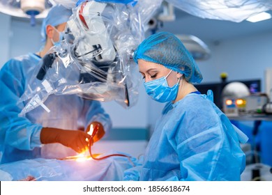 Selective Focus On Neurosurgery Operation Process. Woman Nurse Assistant In Operating Room. Modern Clinic Interior.