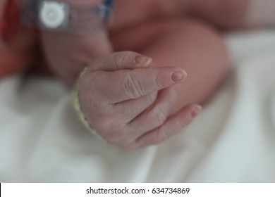 A selective focus on newborn right index finger with blurred background and fingers sign showing the meaning of I LOVE YOU hand sign