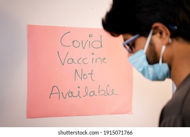 Selective Focus On Notice Board, Young Man Got Worried After Looking Covid-19 Vaccine Not Available Notice Board On Hospital Door - Concept Of Coronavirus Vaccine.