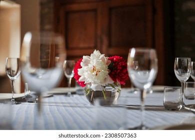 selective focus on peonies centerpiece on a country chic set table in springtime