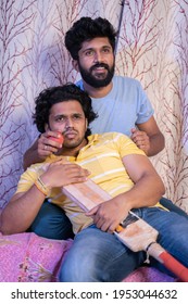 Selective Focus On Person Holding Bat, Vertical Shot Of Two Young Sports Fans Holding Cricket Bat And Ball Watching Interesting Cricket Match On Television From Home