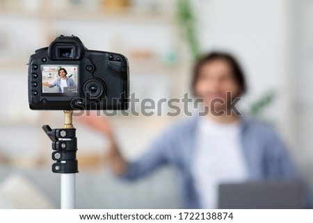 Selective focus on prof camera shooting video blogger at home
