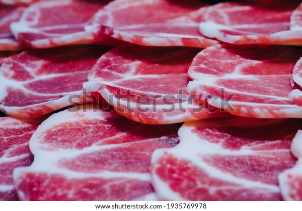 Selective\
focus on raw cut beef slice for piece on the dish for shabu or\
yakiniku as korean and japanese buffet\
food