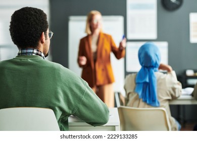 Selective focus on rear view of young Middle Eastern highschool male student sitting by desk at lesson of foreign language - Shutterstock ID 2229133285