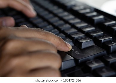 selective focus on the return key or enter key of black keyboard of desktop being pressed by a human finger