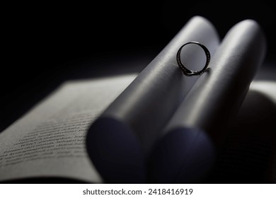 Selective focus on the ring on the open book results in a heart-shaped shadow. Romantic. A symbol of love.