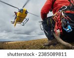 Selective focus on safety harness of paramedic of emergency service in front of landing helicopter. Themes rescue, teamwork and hope.
