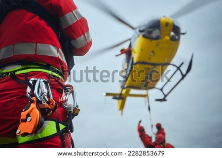 Selective focus on safety harness of paramedic of emergency service in front of helicopter. Themes rescue, help and hope.
