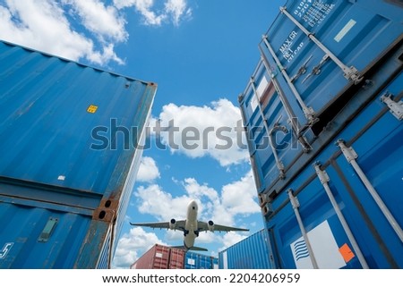 Selective focus on stack of blue container. Airplane flying above logistic container. Air logistics. Cargo and shipping business. Container ship for import and export logistic. Logistic industry. 