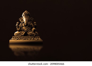 Selective focus on statue of Lord Ganesha, Ganesha Festival. Hindu religion and Indian celebration of Diwali festival concept on dark, red, yellow background. Festival and religious concept