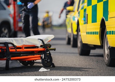 Selective focus on stretcher against ambulance cars of emergency medical service, firefighters and rescue helicopter on road. Themes rescue, urgency and health care.	
 - Powered by Shutterstock