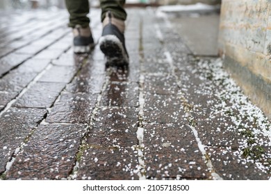 Selective focus on technical salt grains on icy sidewalk surface in wintertime, used for melting ice and snow. Applying salt to keep roads clear and people safe in winter weather from ice or snow - Shutterstock ID 2105718500