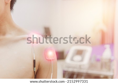Selective focus on TENS Electrode Pads prepare for treatment on shoulder pain, Electro stimulation machine in rehab room on the background in hospital, health problem and medical concept.
