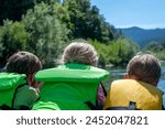 Selective focus on three children peering over a raft going down the wild and scenic Rogue River 