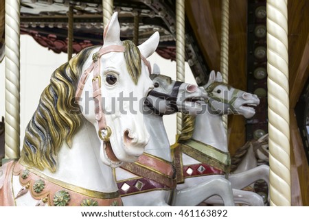 Selective focus on three white carousel horses