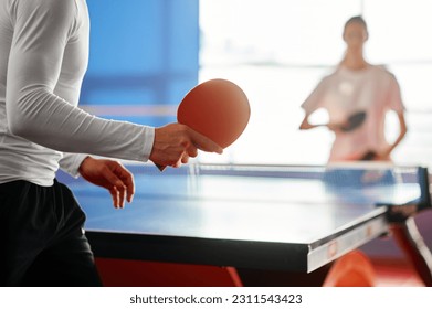 Selective focus on two sportive people playing table tennis indoors - Powered by Shutterstock