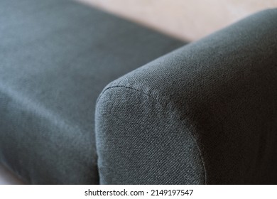 Selective focus on upholstery of new couch. Cleaning service, repair and restoration furniture concept. Close up view of green textile on comfortable sofa or armchair in apartment