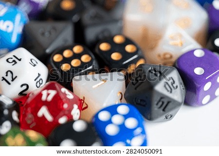Selective focus on white perled d4 and black d20 dice surrounded by colorful dice
