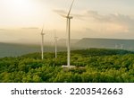 Selective focus on wind farm. Wind energy. Wind power. Sustainable, renewable energy. Wind turbines generate electricity. Windmill farm on mountain. Green technology. Sustainable resources.